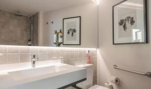 a white bathroom with a sink and a mirror at Pousada Alfama in Lisbon