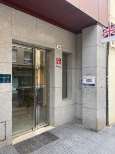 einen Eingang zu einem Gebäude mit einer Glastür in der Unterkunft Victoria 68 SUITE in Málaga