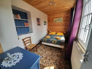 a bedroom with a bed and a table in a room at Chambres d'hôtes L'Oustal in Oloron-Sainte-Marie