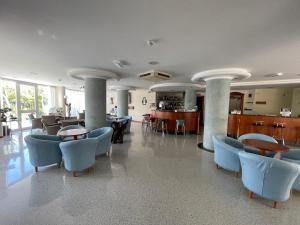 eine Lobby mit Tischen und Stühlen in einem Gebäude in der Unterkunft Hotel Pari in Misano Adriatico