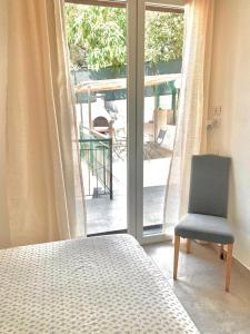 - une chambre avec un lit et une chaise à côté d'une fenêtre dans l'établissement Officine Bel Sit, à Bordighera