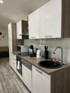 a kitchen with white cabinets and a sink at Apartman Rakovac in Karlovac