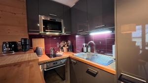 een keuken met een spoelbak en een fornuis bovenste oven bij Le 41 du Lyret - Appartement type studio pour deux avec vue sur les Aiguilles dans Chamonix Centre in Chamonix-Mont-Blanc