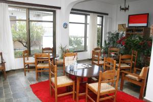 ein Esszimmer mit einem Tisch, Stühlen und Fenstern in der Unterkunft Aparthotel Iliahtides in Amarinthos