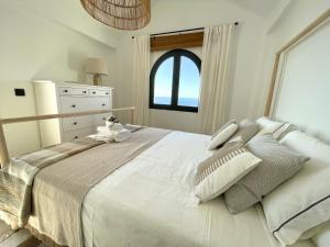 een slaapkamer met een groot wit bed met een raam bij Casa Kalithea in La Herradura +20 foto's