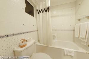 La salle de bains blanche est pourvue de toilettes et d'une baignoire. dans l'établissement Hotel Castille, à La Valette