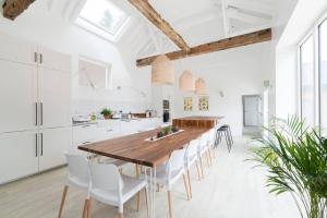 a kitchen and dining room with a wooden table and chairs at Simple Coastal Luxury near Southwold sleeps 10 in Southwold