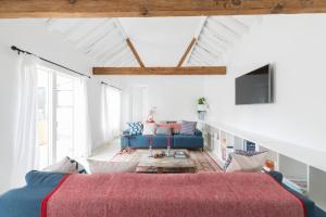 a living room with a blue couch and a tv at Simple Coastal Luxury near Southwold sleeps 10 in Southwold