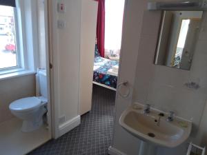a bathroom with a sink and a toilet and a window at Southview Hotel in Blackpool