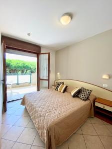 ミラノ・マリッティマにあるResidence Pineta Verdeのベッドルーム(大型ベッド1台、大きな窓付)
