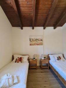 a bedroom with two beds and a wooden ceiling at Penthouse Andrea in Meina +28 photos