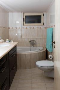 a bathroom with a tub and a toilet and a sink at House with Garden near the Beach in Heraklio