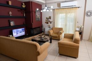 a living room with couches and a flat screen tv at House with Garden near the Beach in Heraklio