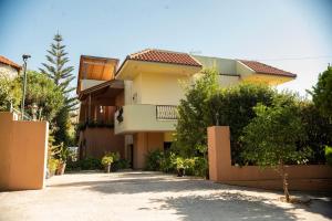 a yellow house with a fence in front of it at House with Garden near the Beach in Heraklio