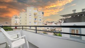 - deux chaises blanches sur un balcon avec des bâtiments dans l'établissement Kafkas Hotel, à Antalya