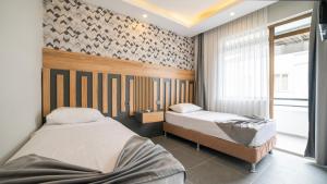 a bedroom with two beds and a window at Kafkas Hotel in Antalya