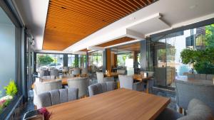 un restaurant avec des tables et des chaises en bois ainsi que des fenêtres dans l'établissement Kafkas Hotel, à Antalya
