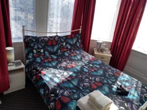 a bedroom with a bed with a butterfly comforter at Southview Hotel in Blackpool