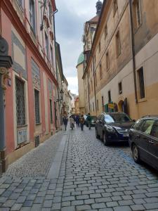 een geplaveide straat in een stad met auto's bij Soukromý pokoj v srdci Prahy in Praag