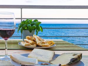 una mesa con un plato de queso y una copa de vino en La Vela, en Finale Ligure