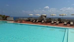 a large swimming pool with chairs and umbrellas at La Vela in Finale Ligure