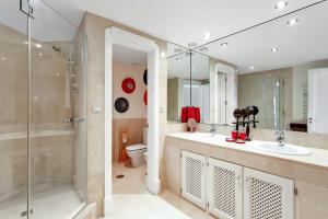 a bathroom with two sinks and a shower and a toilet at YOLO Spaces - Sotogrande - Puerto Boutique Apartment in Sotogrande