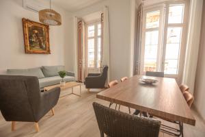 sala de estar con mesa y sofá en Apartamentos Catedral en Málaga