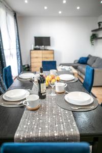 uma mesa com pratos e uma garrafa de vinho em Cosy Space Apartment em Tychy