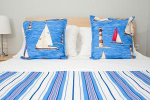 Una cama con almohadas azules y blancas con velas. en Apartments More, en Perea
