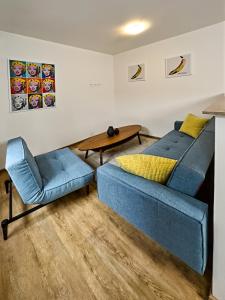 sala de estar con sofá azul y mesa en Gallery Apartments, en Liberec