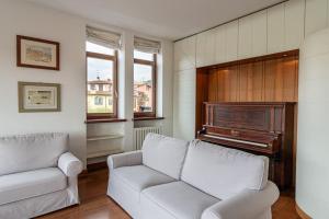 ein Wohnzimmer mit Sofa und Klavier in der Unterkunft Domus Verona - Residenza Ponte Pietra in Verona