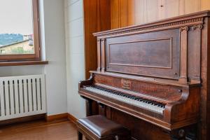 ein Klavier in einem Raum neben einem Fenster in der Unterkunft Domus Verona - Residenza Ponte Pietra in Verona