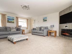 a living room with two couches and a fireplace at Trewenna in Helston