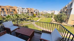 a balcony with chairs and tables and a view of buildings at Sodic Westown Residence 3 in Sheikh Zayed