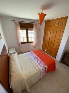 1 dormitorio con 1 cama y puerta de madera en Apartamento en la costa de Almería ( Palomares ) en Palomares