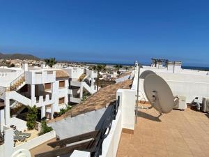 un balcón con edificios blancos y el océano en Apartamento en la costa de Almería ( Palomares ) en Palomares