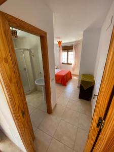 Habitación con baño, cama y puerta. en Apartamento en la costa de Almería ( Palomares ) en Palomares