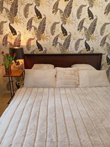 1 dormitorio con cama y pared con papel pintado floral en Apartament blisko dwóch jezior na Warmii i Mazurach, en Biskupiec