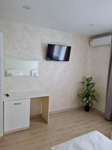 Zimmer mit einem Schreibtisch und einem TV an der Wand in der Unterkunft Hotel Lime in Kiew
