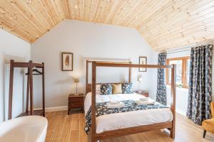 a bedroom with a bed with a wooden ceiling at Kestrel Lodge 3 with Hot Tub in Newton Stewart