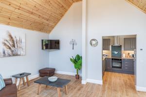 un soggiorno con un divano e un tavolo di Kestrel Lodge 3 with Hot Tub a Newton Stewart Altre 19 foto