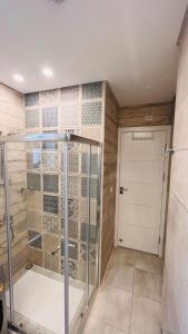 um chuveiro com uma porta de vidro na casa de banho em Sodic Westown Residence 3 em Sheikh Zayed