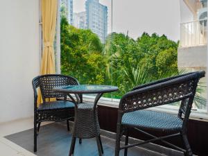 a table and two chairs on a balcony with a window at Hotel Aura - Near Malad Link Road in Mumbai