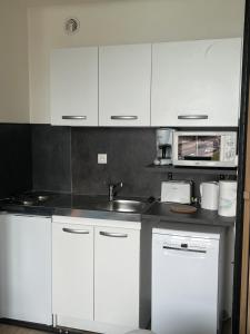 a kitchen with white cabinets and a sink at Vivez la Marina - Plage - Port de plaisance in Le Havre