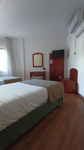 a bedroom with a bed and a flat screen tv at Hotel Boomerang in Valverde