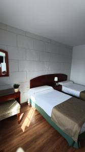 a bedroom with two beds and a wall at Hotel Boomerang in Valverde