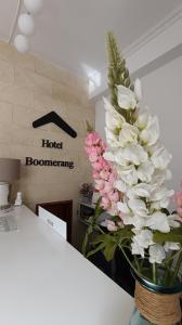 a vase filled with white and pink flowers on a counter at Hotel Boomerang in Valverde