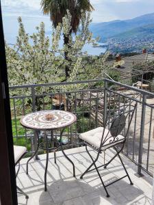 una mesa y una silla en un balcón con vistas en Ema 2, en Matulji