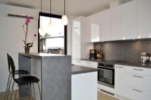 a kitchen with white cabinets and a black counter top at Härmati puhkemaja- Riverside Holiday Home in Nasva