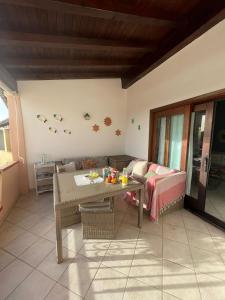 a living room with a table and a couch at Casa Souad, a cheerful and charming beach view 2 bedroom house and free parking in Porto San Paolo